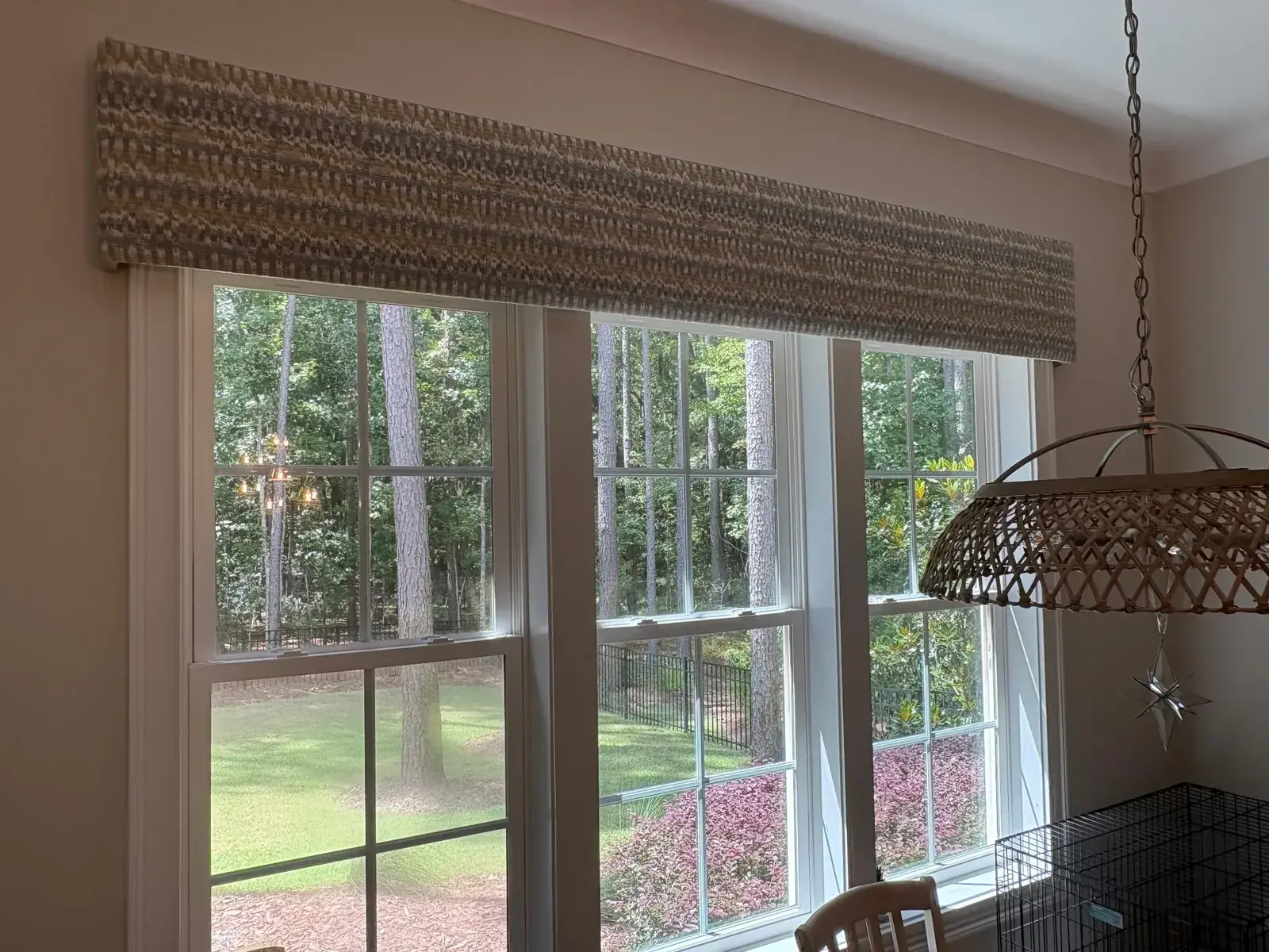 Woven cornice board above a pair of tall windows