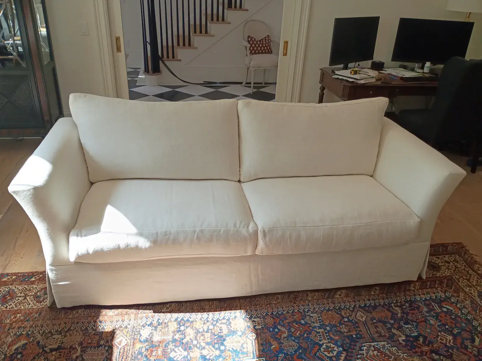 Ivory sofa with loose seat and back cushions in a living room