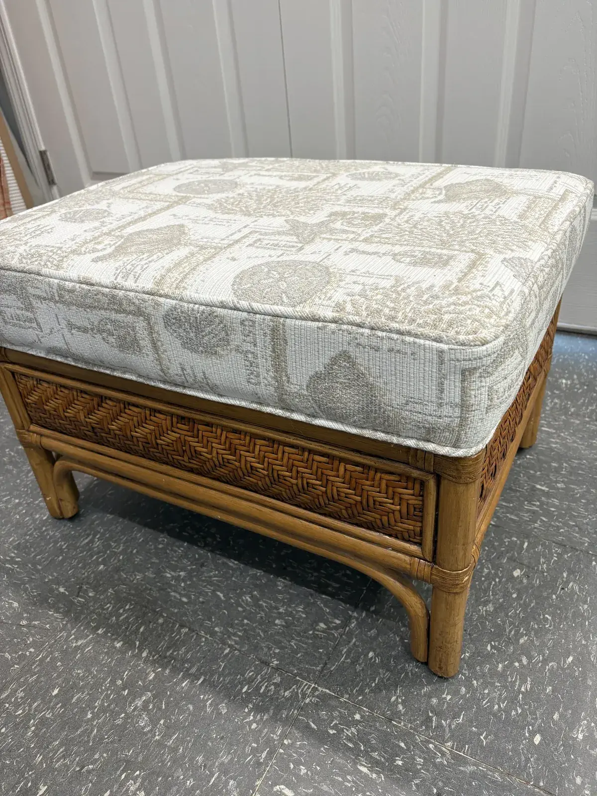Rattan ottoman with a box cushion in cream and gray print